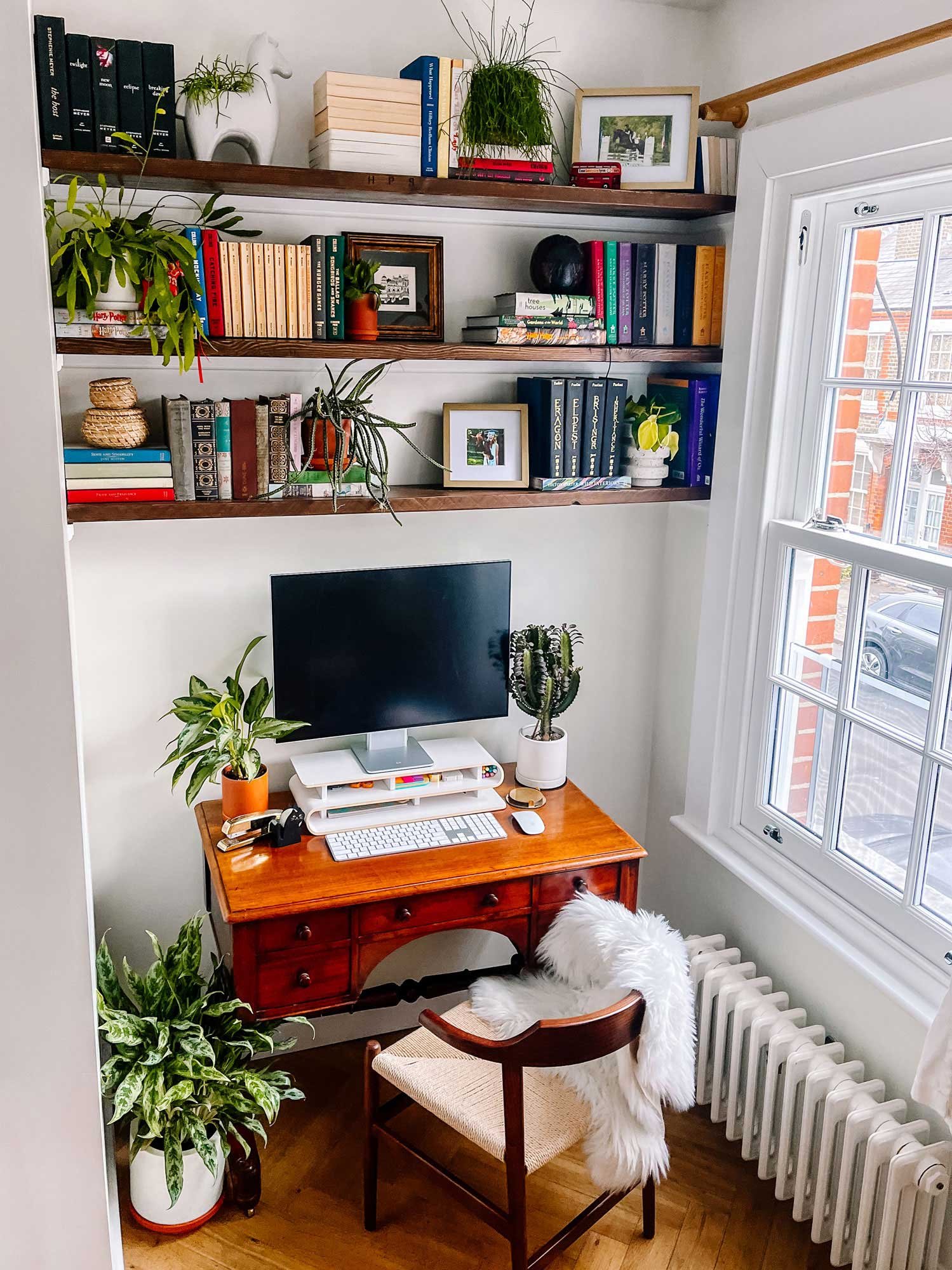 Small home office nook with plants and built-in shelves